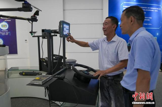 图为参观者在国家农机装备创新中心体验操作电机式北斗农机自动驾驶仪。中新社记者 范晓恒 摄